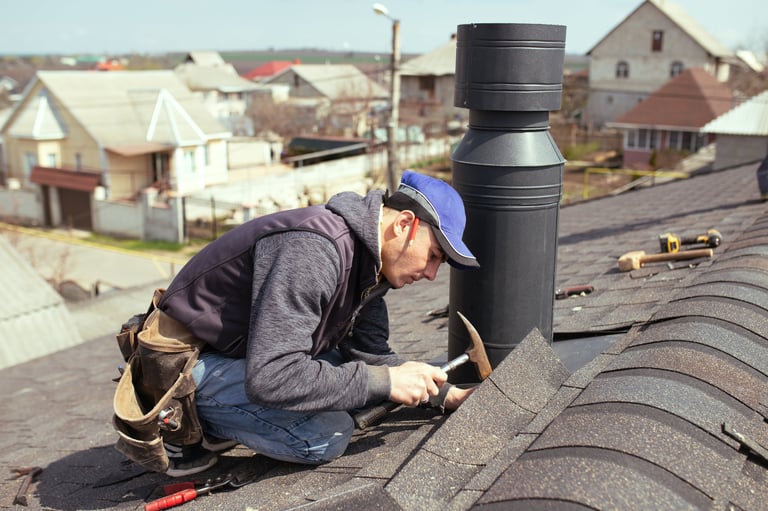a professional master roofer with hammer repairs the roof