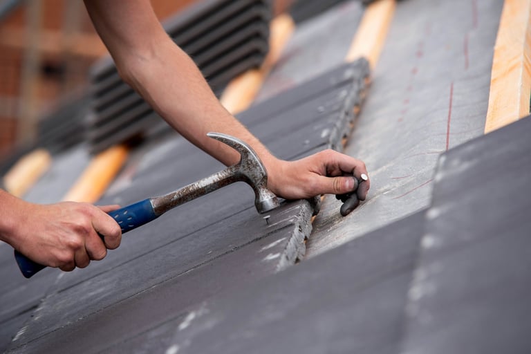 Close-up of skilled builder hands carefully placing roofing tiles